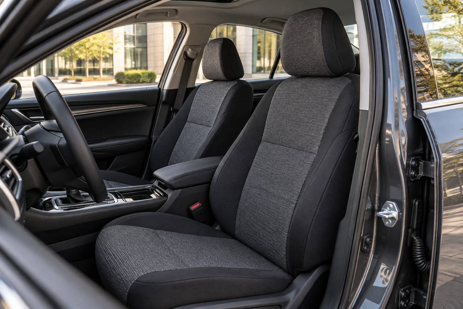 Graphite seat covers in a sedan outside a modern office
